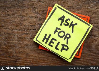 Ask for help advice or reminder - handwriting on a sticky note against rustic wood