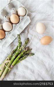 Asparagus and eggs on a fabric linen background. The concept of a healthy and healthy breakfast. Place for an inscription. Asparagus and eggs on a fabric linen background. The concept of a healthy and healthy breakfast. Place for an inscription.