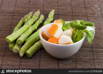 asparagus and surimi. a cup with surimi and salad and asparagus