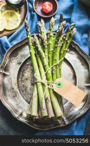 Asparagus bunch with blank paper label , top view, close up, copy space
