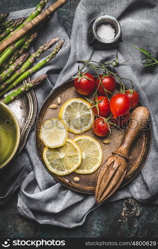 Asparagus cooking ingredients with kitchen tools on rustic napkin background, top view. Dark style