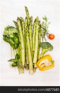 Asparagus with green vegetables for tasty cooking on white wooden background, top view. Vegan or vegetarian nutrition, diet, detox and healthy food concept