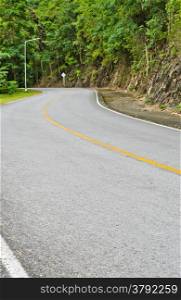 Asphalt curved road in tropical rain forest