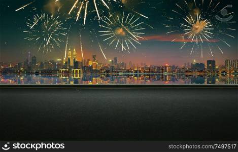 Asphalt empty road side with city skyline and firework sky background . Night scene with firework celebration .