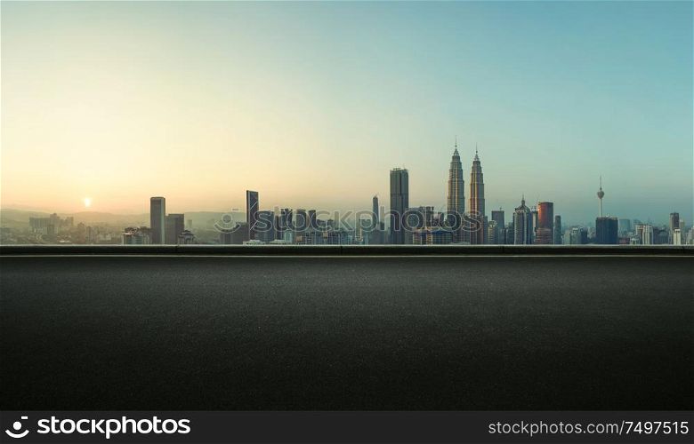 Asphalt empty road side with Kuala Lumpur city skyline background . Sunrise scene .