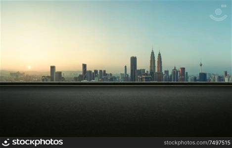 Asphalt empty road side with Kuala Lumpur city skyline background . Sunrise scene .