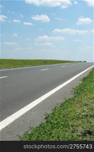Asphalt road. A transport highway with the blue sky. A transport highway with the blue sky