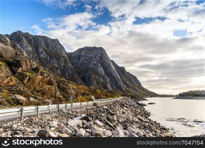 Asphalt road along mountain and sea with blue sky, Norway, selective focus