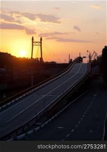 Asphalt road and bridge. Highway, night time, yellow sunset