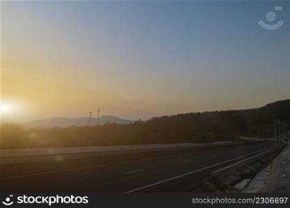 Asphalt road and mountain landscape at sunset sky background. Country road and mountains.