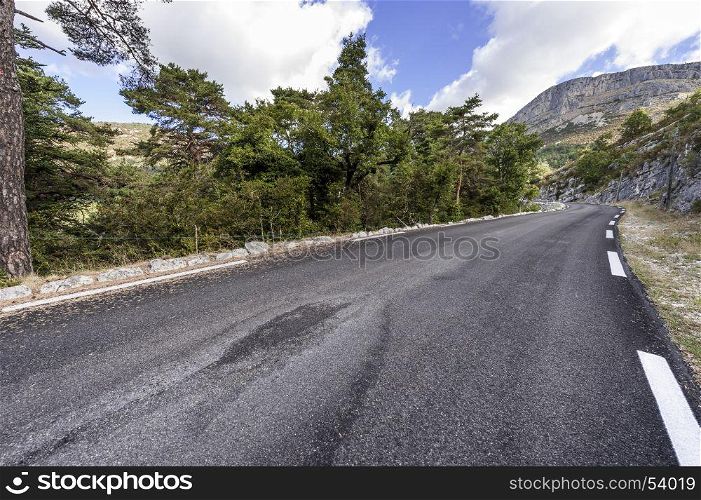 Asphalt road between forests in Provence-Alpes-Cote d Azur region in southeastern France.