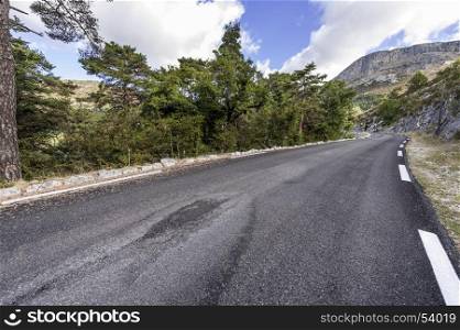 Asphalt road between forests in Provence-Alpes-Cote d Azur region in southeastern France.