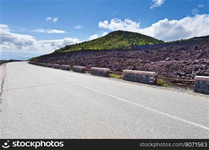 Asphalt Road between the Black Lava Covered Slopes of Mount Etna in Sicily