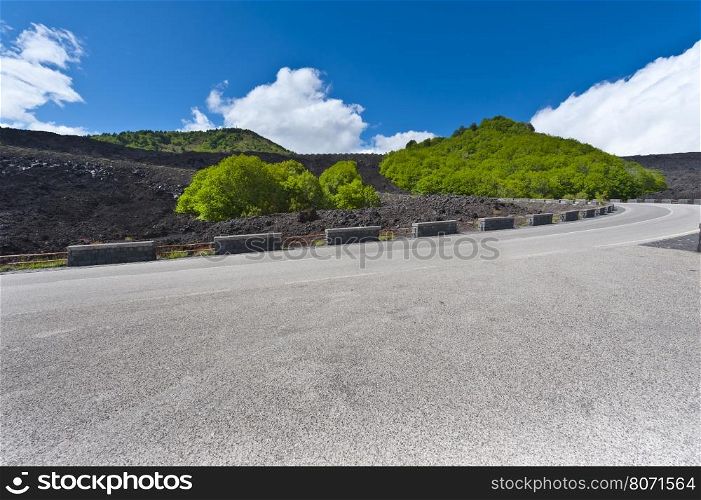 Asphalt Road between the Black Lava Covered Slopes of Mount Etna in Sicily