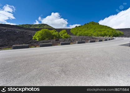 Asphalt Road between the Black Lava Covered Slopes of Mount Etna in Sicily