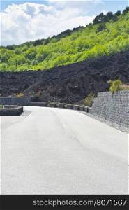 Asphalt Road between the Lava and Bush Covered Slopes of Mount Etna in Sicily