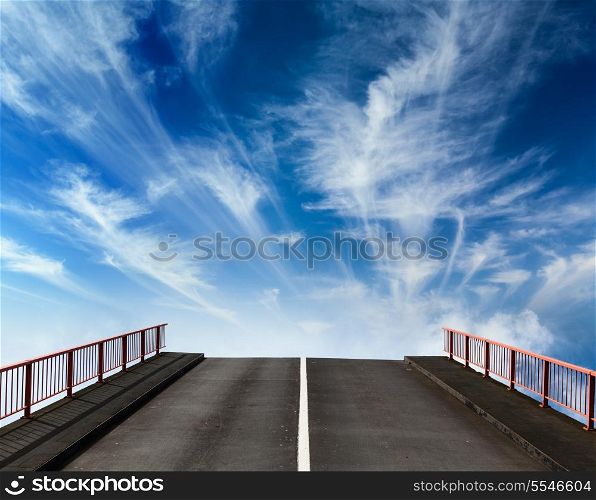 Asphalt road going into sky with clouds