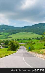 Asphalt Road in Green Sloping Meadows of Tuscany