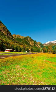 Asphalt Road Leading to the Snowy Peaks of the Alps