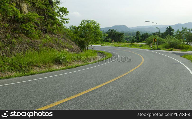 Asphalt road sharp curve along with tropical forest zigzag ahead.