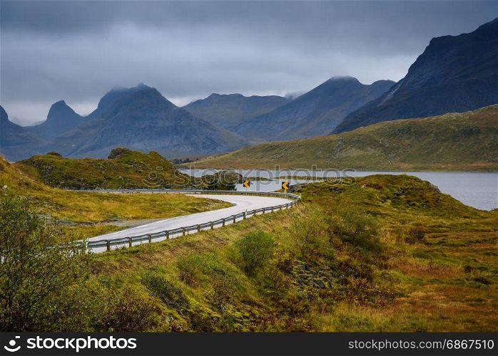 Asphalt sharp curved road along the forest and mountain, Lofoten, Norway