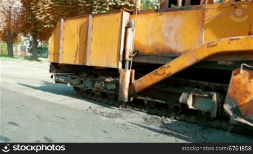 asphalt spreader is used to place the first layer of asphalt on a city street renewal project