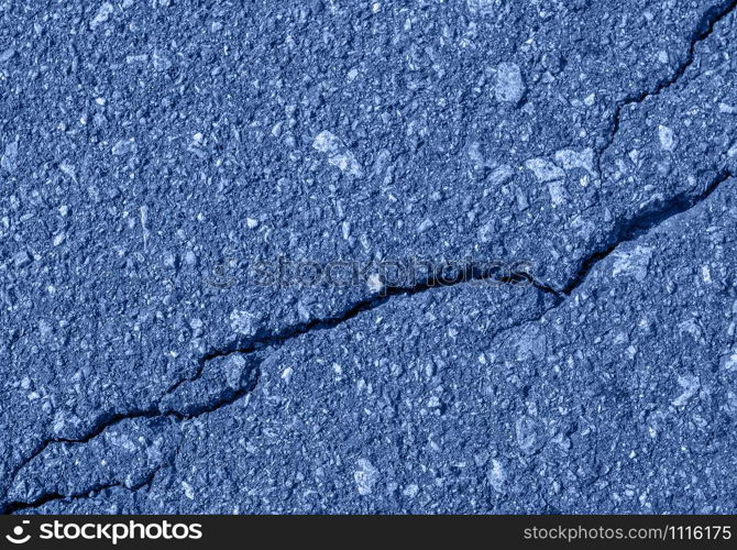 Asphalt with crack background. Old toned blue road for background or texture. Asphalt as abstract background or backdrop. Trendy banner toned in classic blue - color of the 2020 year. Asphalt with crack background. Old toned blue road for background or texture.