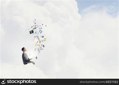 Aspiration for education. Young businessman sitting on cloud with book and icons flying in air