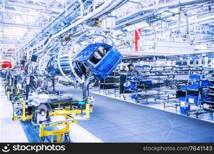 Assembling cars on conveyor line in car plant. Assembling cars on conveyor line