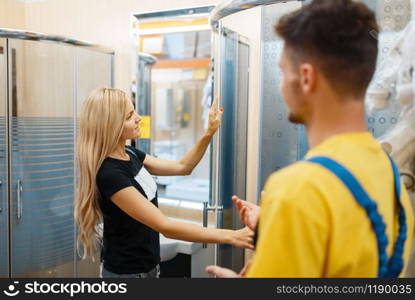 Assistant and female consumer in hardware store. Seller in uniform and woman in diy shop, shopping in building supermarket. Assistant and female consumer in hardware store