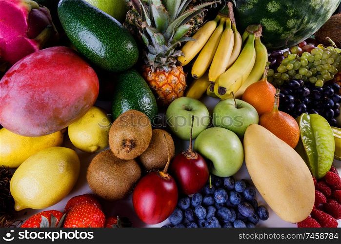 Assorted background of many tropical colorful fruits harvest. Tropical fruits background
