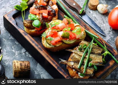 Assorted bruschetta with various toppings.Italian bruschetta on wooden cutting board. Bruschetta with various toppings