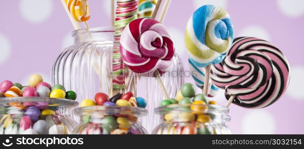 Assorted candies including lollipops, gum balls. Colorful lollipops and different colored round candy and gum balls