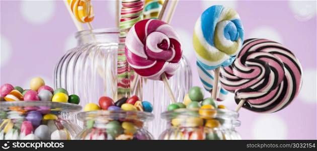 Assorted candies including lollipops, gum balls. Colorful lollipops and different colored round candy and gum balls
