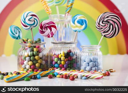 Assorted candies including lollipops, gum balls. Colorful lollipops and different colored round candy and gum balls