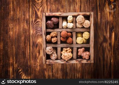 Assorted Chocolate candies in wooden box sells. Luxury handmade sweets. Chocolate candy box