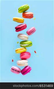 Assorted colorful macaroons falling cookies on blue background. Macaroons cookies on pink. Macaroons cookies on pink