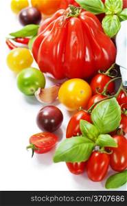 Assorted colorful tomatoes and herbs on white background - healthy eating concept