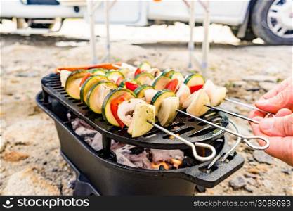 Assorted delicious grilled vegetable skewers on barbecue grill. Barbeque dinner outdoor. Rv camper in the background.. Grilled vegetables on barbecue grill. Rv in the distance