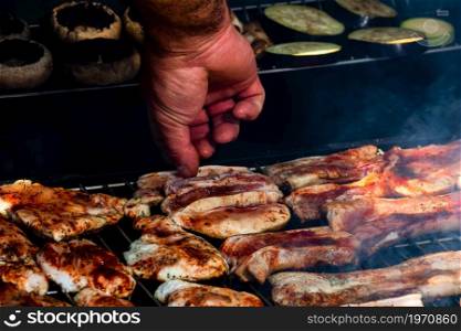 Assorted delicious tasty grilled meat with vegetables being cooked on charcoal grill