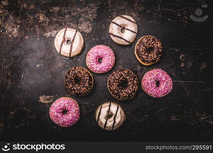 assorted donuts with chocolate on dark background