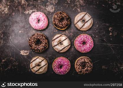 assorted donuts with chocolate on dark background
