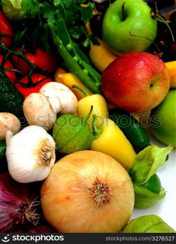 Assorted fresh fruit and vegetables with onions, garlic an tomatillos in the foreground. Vegtables And Fruit