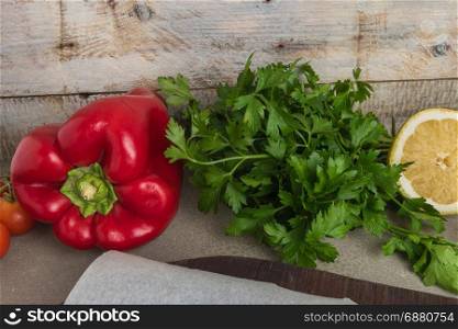 Assorted fresh healthy organic vegetables. Parsley, tomatoes red pepper and Lemon on top of wooden table