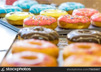 assorted glazed doughnuts in different colors on background
