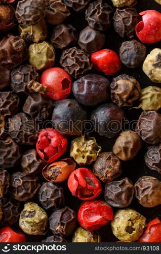 Assorted pepper corns. Backgrounds and textures: a lot of multicolored pepper corns, close-up shot, culinary abstract