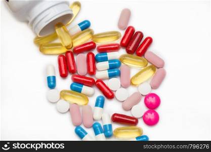 Assorted pharmaceutical medicine pills, tablets and capsules and bottle on white background. Copy space for text colorful. Assorted pharmaceutical medicine pills, tablets and capsules and bottle on white background. Copy space for text