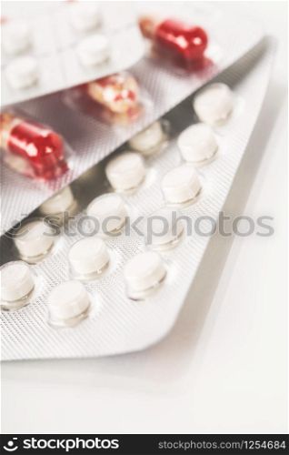 Assorted pharmaceutical medicine pills, tablets and capsules over white background. Medical pharmacy concept