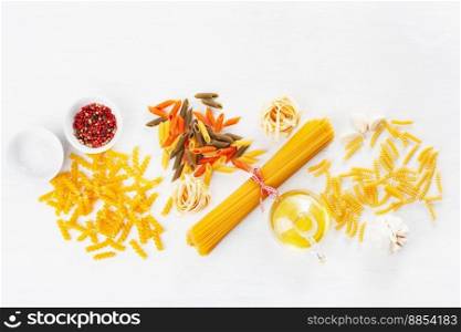assorted raw pasta flat lay on white. spaghetti fusilli penne tagliatelle girandole