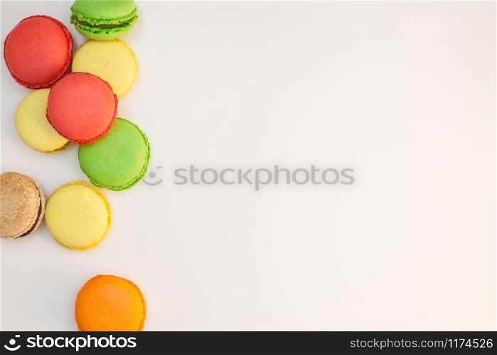 Assorted sweet pastel color macaroons on white background top view. Dessert macaron flat lay.
